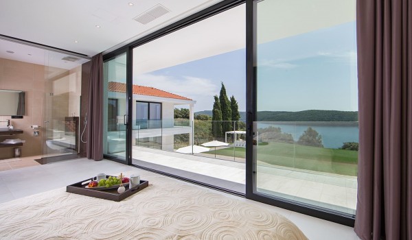 King size bed in a bedroom with en suite bathroom and sea view in a Croatia luxury villa Eden Land in Istria