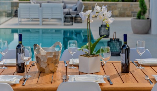 Wooden dining table on the outdoor terrace by the pool in the luxury villa Korcula Prestige on the island of Korcula