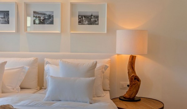 A double bed and a wooden table with a night lamp in the bedroom in the luxury villa Korcula Prestige on the island of Korcula