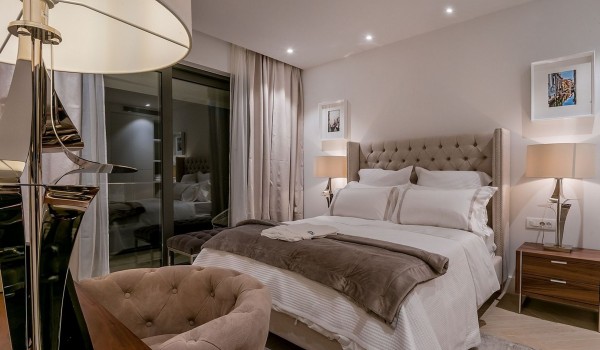 A double bed, a desk with an armchair and a wooden chest of drawers in the bedroom in the luxury villa Korcula Prestige on the island of Korcula