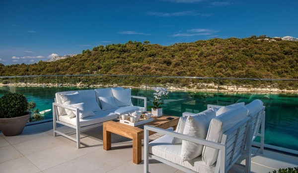 Panoramic view of the sea from the balcony with a sofa set with a coffee table in the luxury villa Korcula Prestige on the island of Korcula