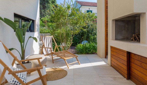 Outdoor dining are with hearth on roofed terrace in family Sutivan luxury villa by the beach with private pool.