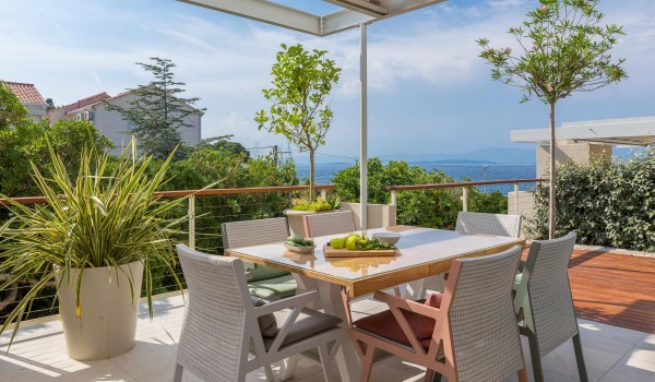 Outdoor dining are with hearth on roofed terrace in family Sutivan Luxury Villa by the beach with private pool.