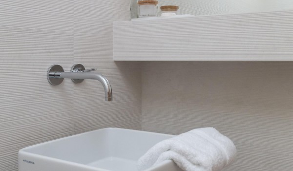 White tiled bathroom with provided towels in modern luxury villa Sutivan by the sea.