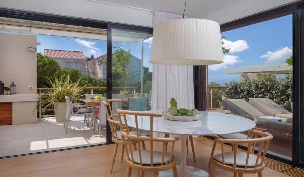 Dining room near pool and summer kitchen in Sutivan luxury villa by the beach for fulfilled vacation and rent.