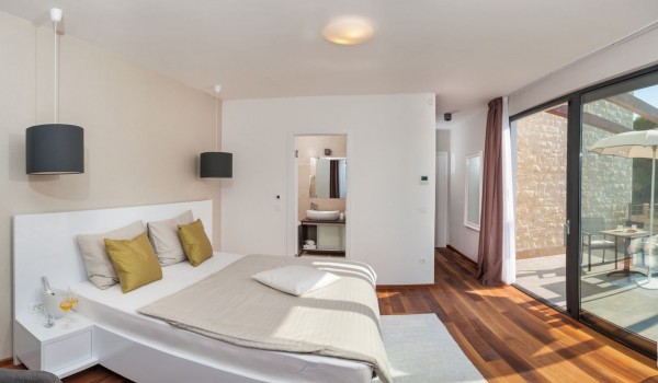 King size bed in a bedroom with private terrace in a Croatia luxury vacation villa with private pool and sauna in Trogir