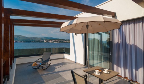 Breakfast table and sun lounger on the private bedroom terrace of a Croatia luxury vacation villa with private pool and parking