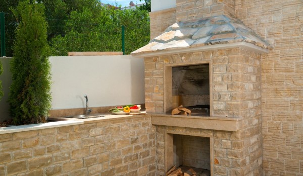 Traditional grill and lawn in the fenced yard of a Croatia  luxury villa Trogir 2 for rent on Ciovo,