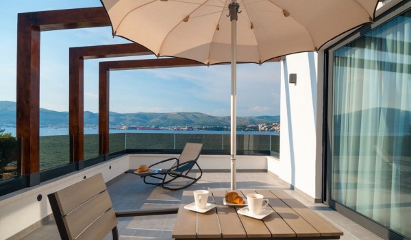 Breakfast table and sun lounger on the private bedroom terrace of a Croatia luxury vacation villa with private pool and parking