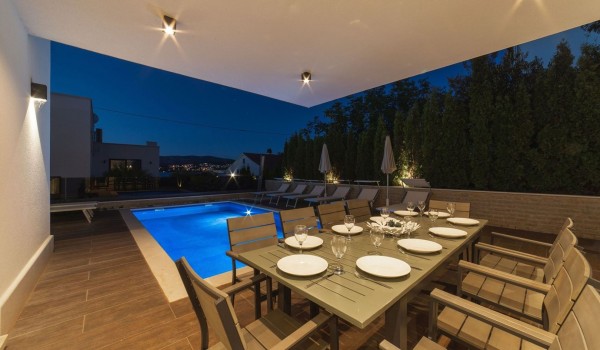 Outdoor dining table by the pool of a Croatia luxury sea view villa Trogir 2 for vacation