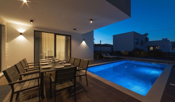 Outdoor dining table by the pool of a Croatia luxury sea view villa Trogir 2 for vacation and rent