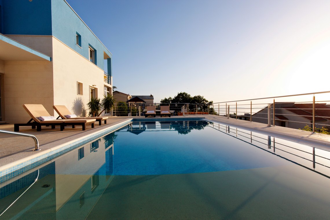 Private Terrasse der kroatischen Luxus-Familienvilla mit Pool, umgeben von Liegestühlen für Urlaub und Miete