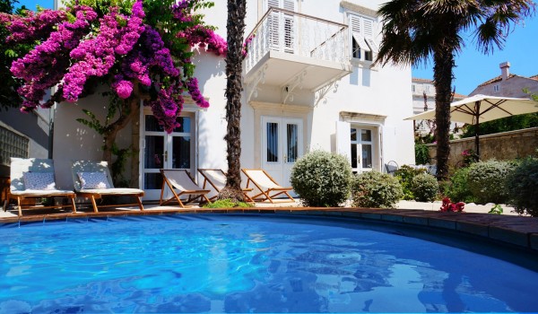 Private swimming pool surrounded by deckchairs for sunbathing in the  Croatian luxury villa Beach House Orebic on Peljesac