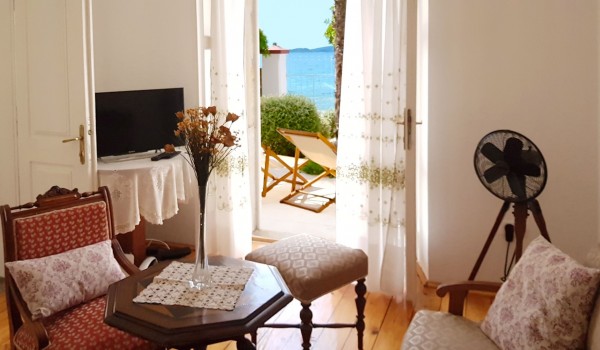 Living room with sofa, table, LCD TV and exit to the outdoor terrace of  Croatian luxury pool villa