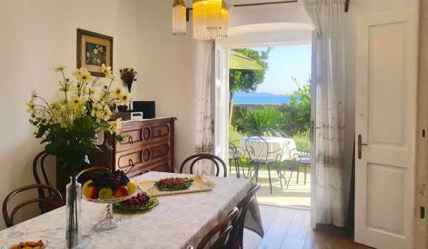 Dining table with chairs, wooden chest of drawers and direct access to the outdoor terrace of the family villa Beach House Orebic with pool