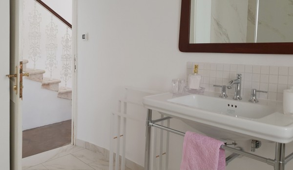 Bathroom equipped with sink and mirror, and stairs leading to the first floor of the villa for rent in Orebic Croatia