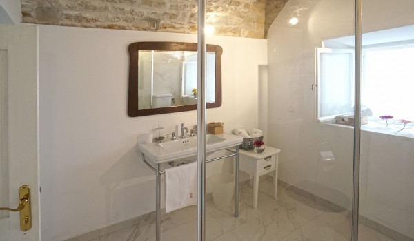 A bathroom with a shower cabin and a sink with a mirror in the sea view villa Beach House Orebic with a private pool on Peljesac