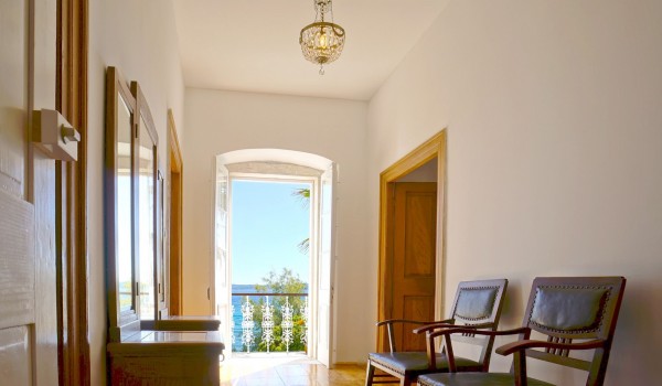 Hallway with a sitting area and a mirror with a view of the sea in a private pool villa for rent in Orebic Croatia