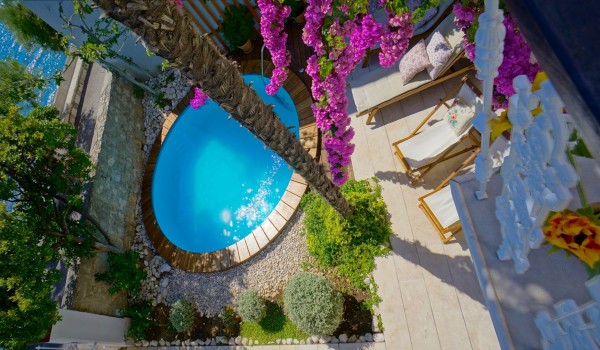 View from the balcony of the villa Beach House Orebic on Peljesac to the outdoor terrace with a swimming pool and deckchairs