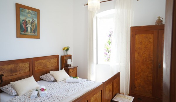 Bedroom with double bed and wooden wardrobe in villa Beach House Orebic for vacation with friends