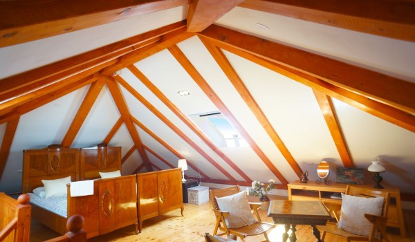 A bedroom with a double bed and a sitting area with chairs and a coffee table