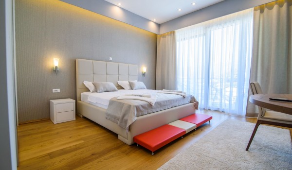 King size bed in an elegant bedroom of a luxury family villa with private pool and parking