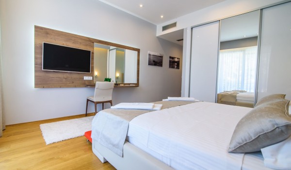 King size bed in an elegant bedroom of a luxury family villa with private pool and parking