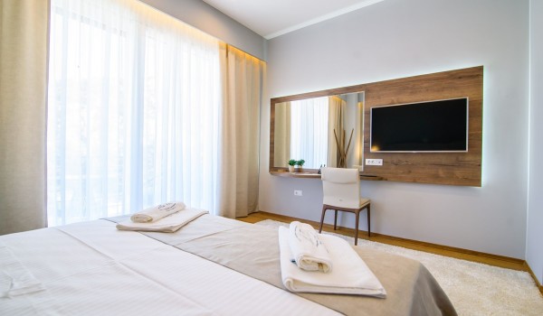 King size bed in an elegant bedroom of a luxury family villa with private pool and parking