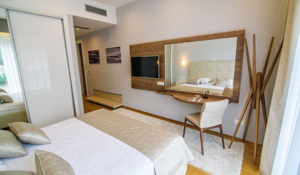 King size bed in an elegant bedroom of a luxury family villa with private pool and parking
