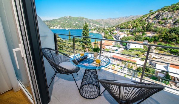 Seating area on the private bedroom balcony of a luxury family villa with private pool and sea view