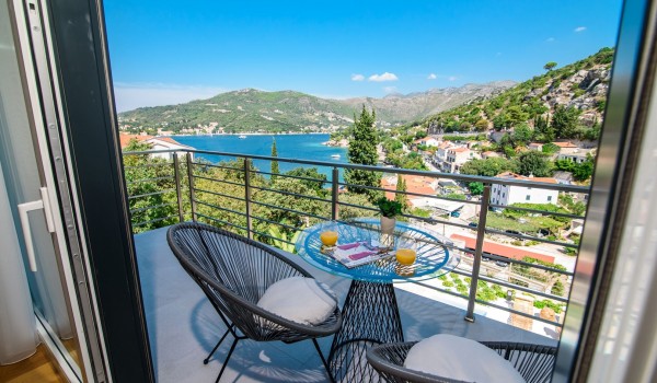Seating area on the private bedroom balcony of a luxury family villa with private pool and sea view