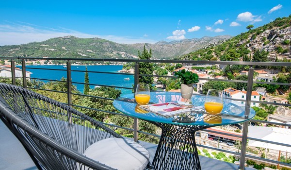 Seating area on the private bedroom balcony of a luxury family villa with private pool and sea view
