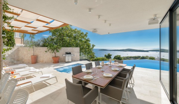 Dining area on the private terrace of the luxurious villa Hvar Fantasy with the lounge chairs and heated pool overlooking the sea in Hvar