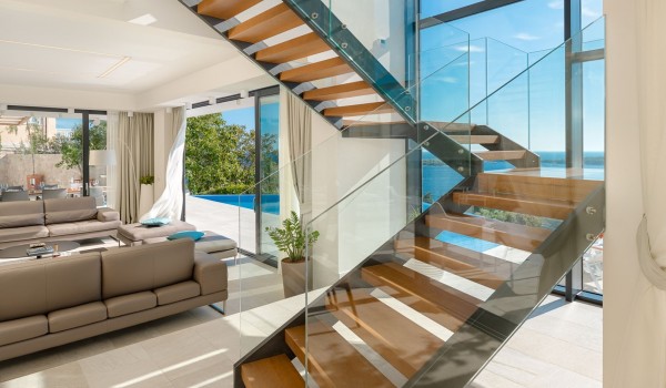 Open space floor-to-ceiling glass windows of the pet-friendly family villa Hvar Fantasy with the living room area overlooking the hetaed private pool on the terrace