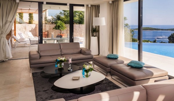 Living room area with the view on the private terrace of the luxurious villa Hvar Fantasy with the private pool and dining table overlooking the sea