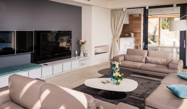 Lounge area with the big smart TV and sofa with direct exit to terrace with heated pool and the sea view in luxury villa Hvar Fantasy