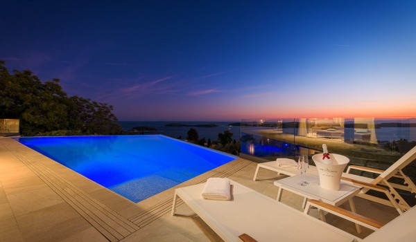 Relaxing outdoor sunset view in Hvar luxury villa Hvar Fantasy with heated pool and lounge chairs overlooking the sea