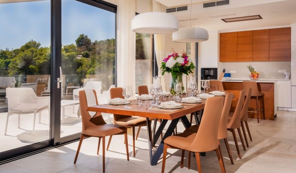 Inside kitchen area and dining table with the floor-to-ceiling glass windows overlooking the private terrace of the luxurious villa Hvar Fantasy for vacation with friends and family