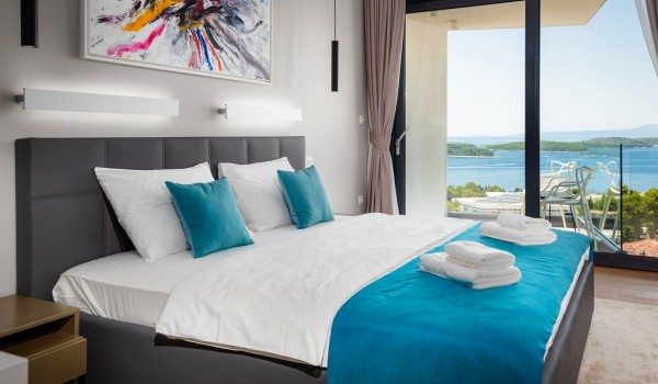 Bedroom with the king size bed and the floor-to-ceiling glass windows with the balcony overlooking the sea for vacation and rent with family and friends