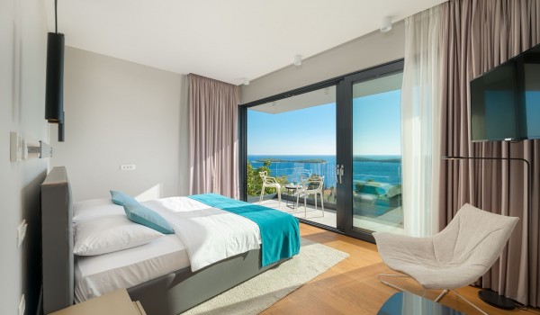 Bedroom with the king size bed and the floor-to-ceiling glass windows with the balcony overlooking the sea for vacation and rent with family and friends