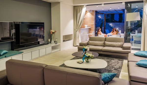 Lounge area with the big smart TV and sofa with direct exit to terrace with heated pool and the sea view in luxury villa Hvar Fantasy