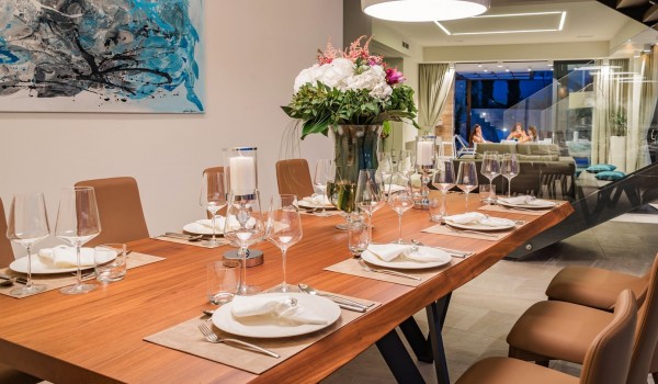 Inside kitchen area and dining table with the floor-to-ceiling glass windows overlooking the private terrace of the luxurious villa Hvar Fantasy for vacation with friends and family