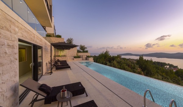 Sunset view on the terrace of Croatia luxury family villa with private pool surrounded by deckchairs