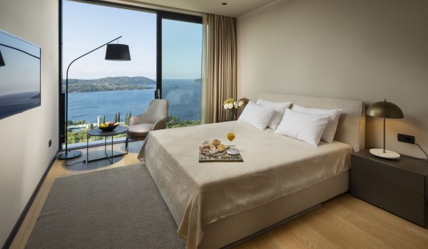 Bedroom of Croatia luxury family villa with king-size bed and seating area with sea view for vacation