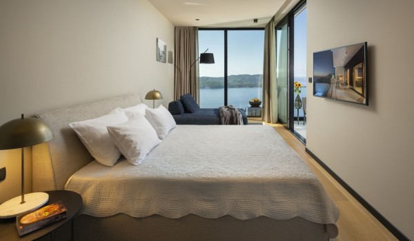 Bedroom of Croatia luxury pool villa with king-size bed and sofa perfect for relaxing with family