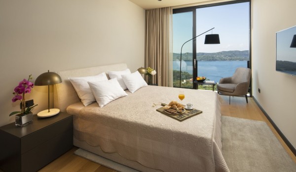 Bedroom of Croatia luxury holiday villa with king-size bed and lounge area by the window with sea view
