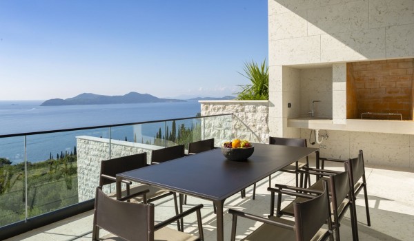 Outdoor dining table with grill on the balcony of Croatia luxury family villa for vacation and rent