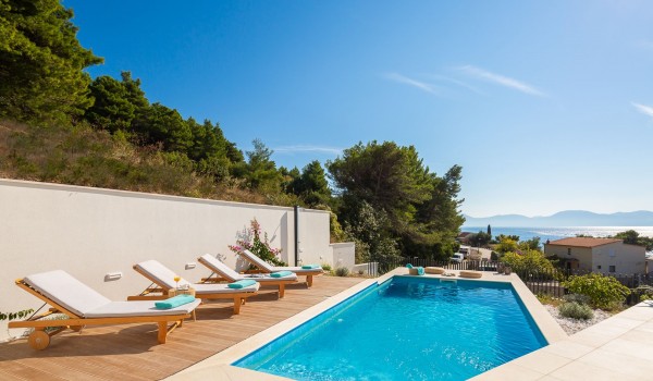Outdoor pool with deck chairs in Makarska Croatian luxury villa for vacation and rent with total privacy.