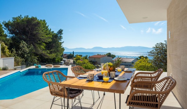 Outdoor dining area near pool of holiday luxury villa Azul in Makarska with sea view.