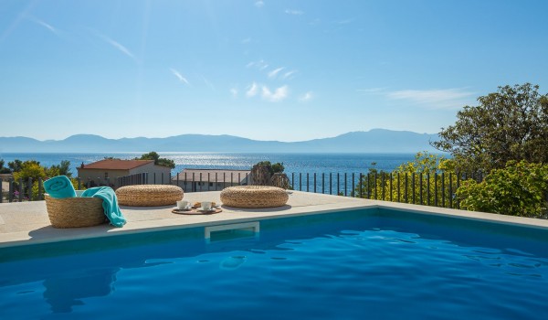 Outdoor pool near sunbathing area with sea view in pet-friendly luxury villa in Makarska for vacation and rent.